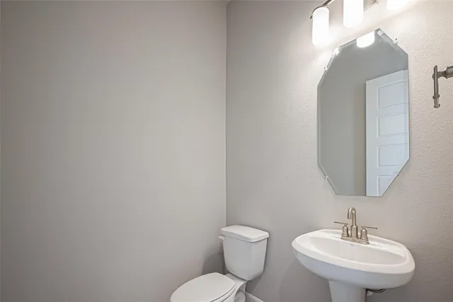 a bathroom with a toilet a sink and mirror