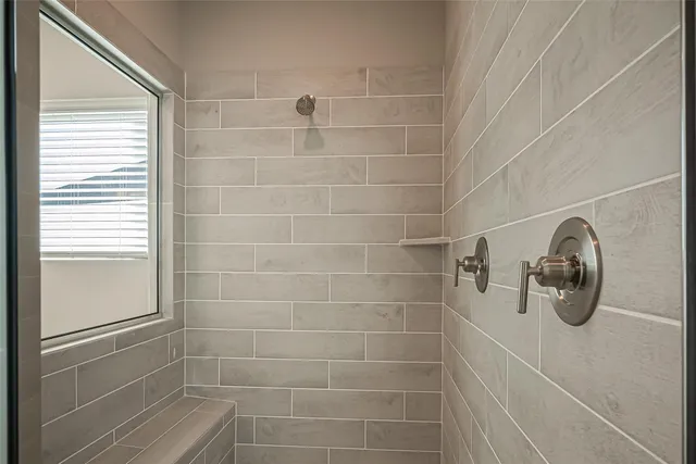a bathroom with a window and a shower