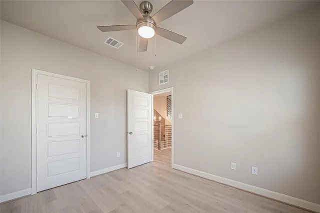 an empty room with fan and a ceiling fan
