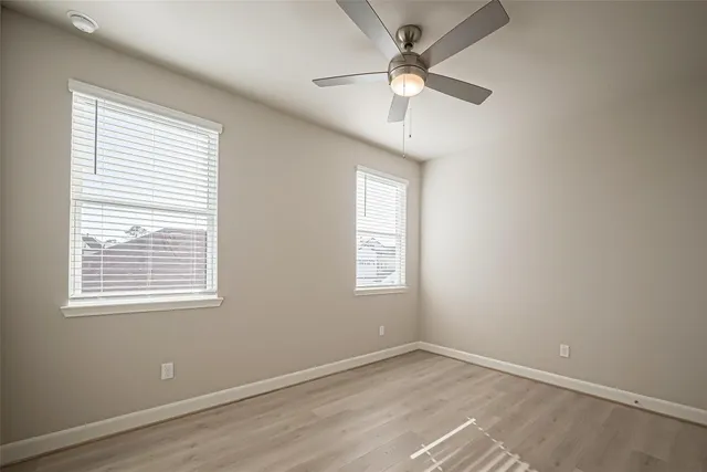 an empty room with a window and a fan