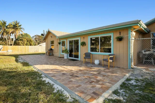 a view of a house with backyard and sitting area