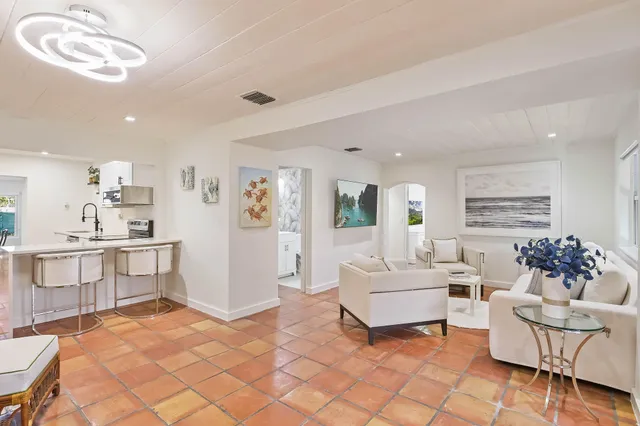 a living room with furniture and a dining table with kitchen view