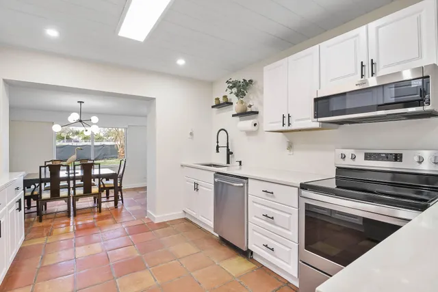 a kitchen with cabinets and chairs