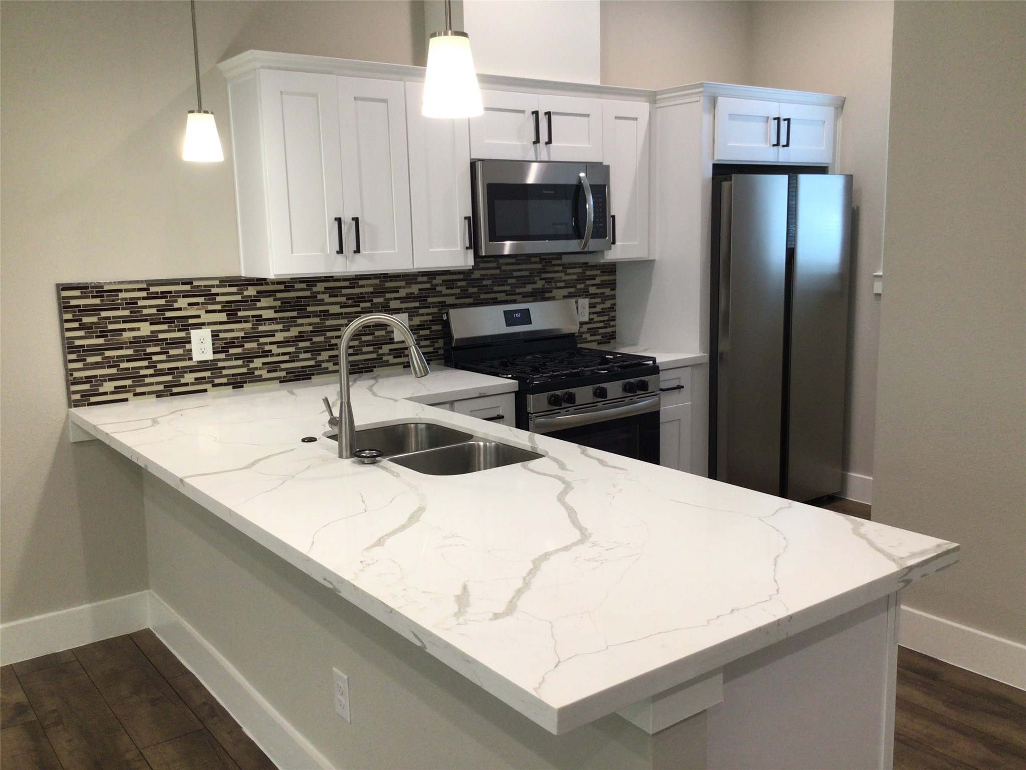 2109 Marnel Road, Unit D Houston, TX 77055 - Photo 10 of 26 a kitchen with a sink a microwave a stove and refrigerator