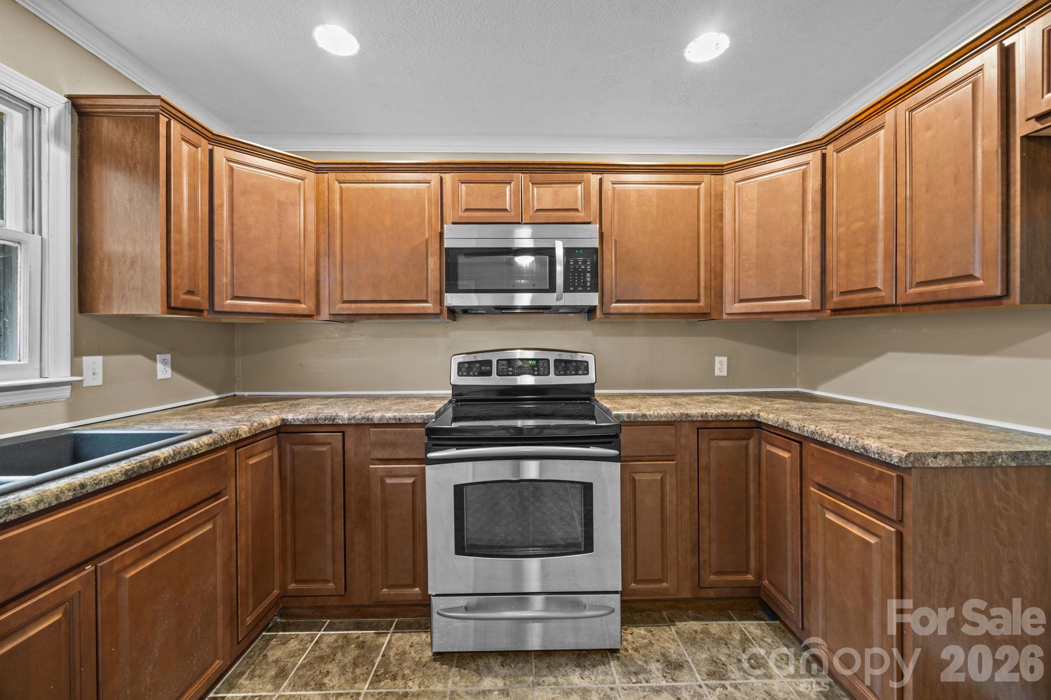 1158 Sunset Court Conover, NC 28613 - Photo 11 of 31 a kitchen with stainless steel appliances granite countertop a stove a sink and a microwave