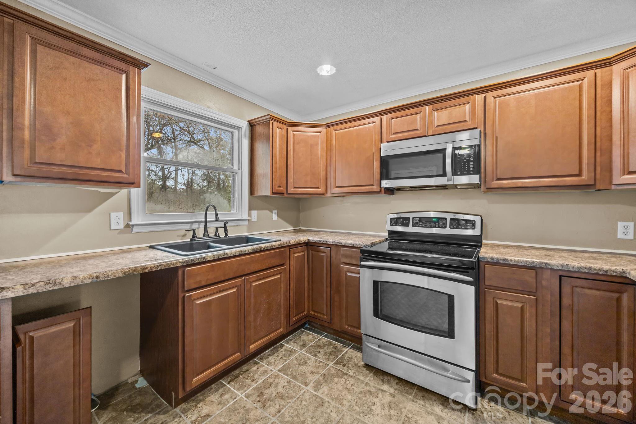 1158 Sunset Court Conover, NC 28613 - Photo 12 of 31 a kitchen with granite countertop a sink stove and microwave