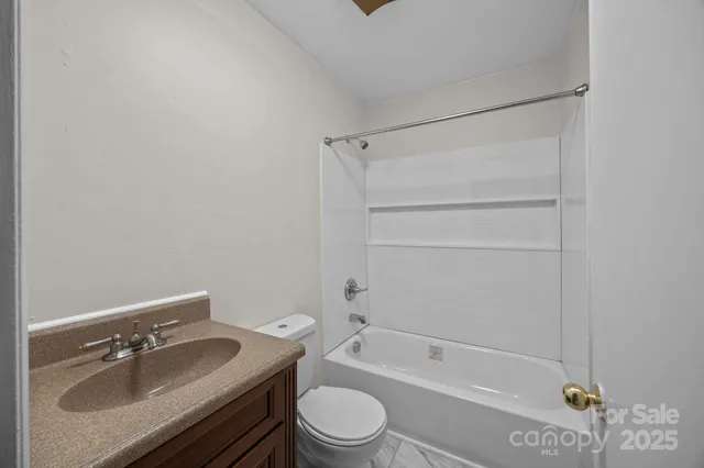 an empty room with a window and a ceiling fan