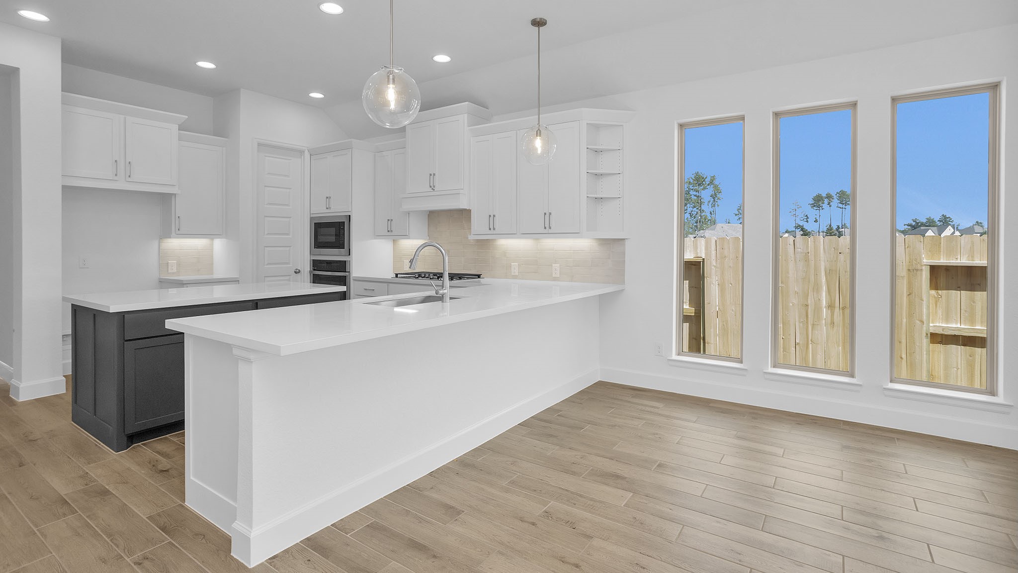18222 Upper Brook Street Conroe, TX 77302 - Photo 13 of 26 a kitchen with kitchen island white cabinets and refrigerator