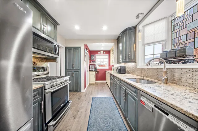 a large kitchen with stainless steel appliances granite countertop a stove and a sink
