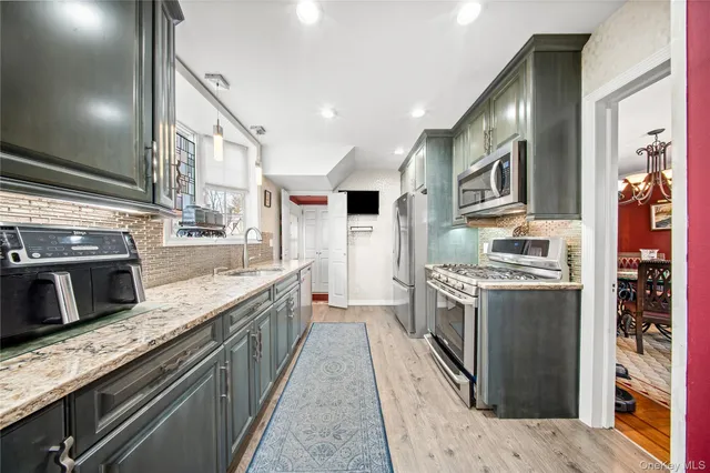 a large kitchen with stainless steel appliances granite countertop a stove and a sink