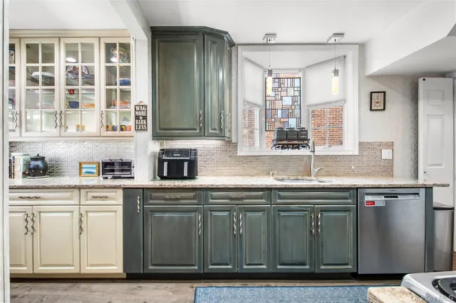 a kitchen with stainless steel appliances granite countertop a sink and cabinets with wooden floor