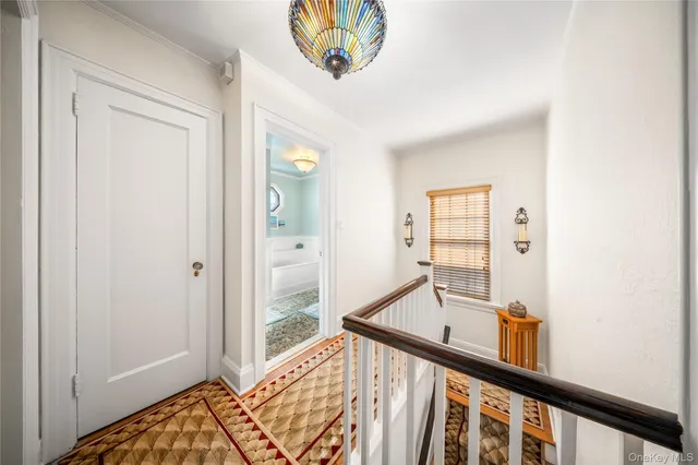 a view of a hallway with a large window and chandelier