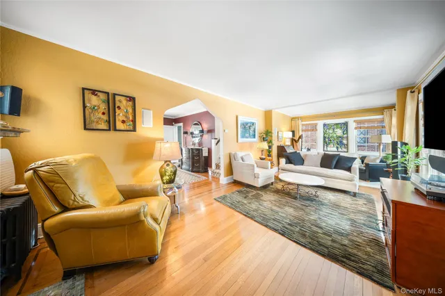 a living room with furniture wooden floor and a large window