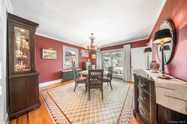 a dining room with furniture a chandelier and wooden floor