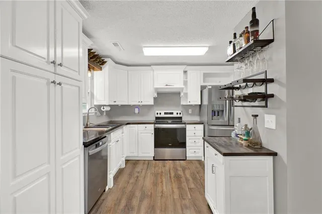 a kitchen with granite countertop white cabinets and appliances