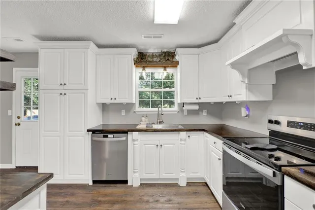a kitchen with stainless steel appliances white cabinets and a refrigerator