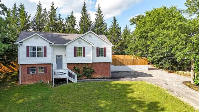 a front view of a house with a garden and trees