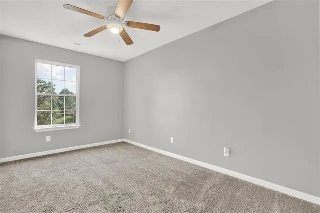 an empty room with closet and a chandelier fan