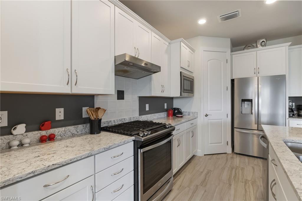 43007 Parkside Court Punta Gorda, FL 33982 - Photo 11 of 44 a kitchen with granite countertop a sink stainless steel appliances and cabinets