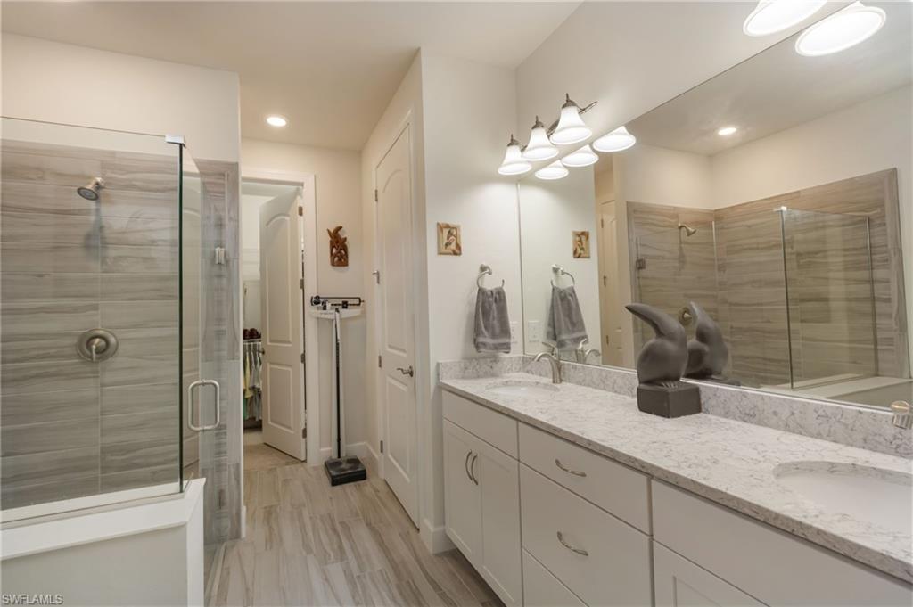 43007 Parkside Court Punta Gorda, FL 33982 - Photo 17 of 44 a bathroom with a double vanity sink mirror and shower