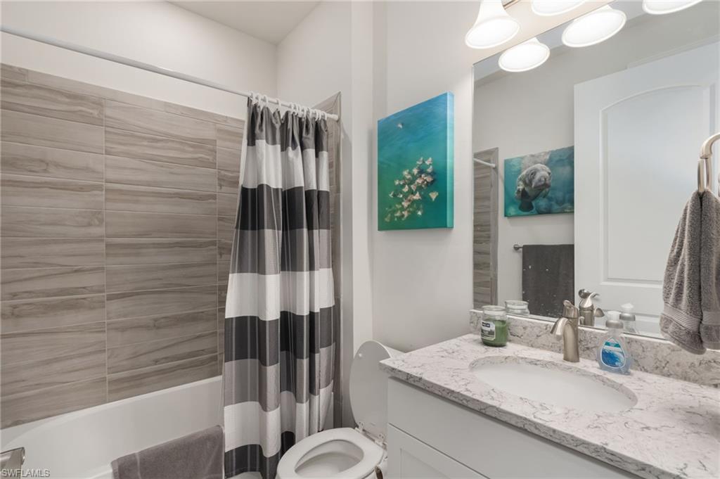 43007 Parkside Court Punta Gorda, FL 33982 - Photo 21 of 44 a bathroom with a granite countertop sink a mirror and shower