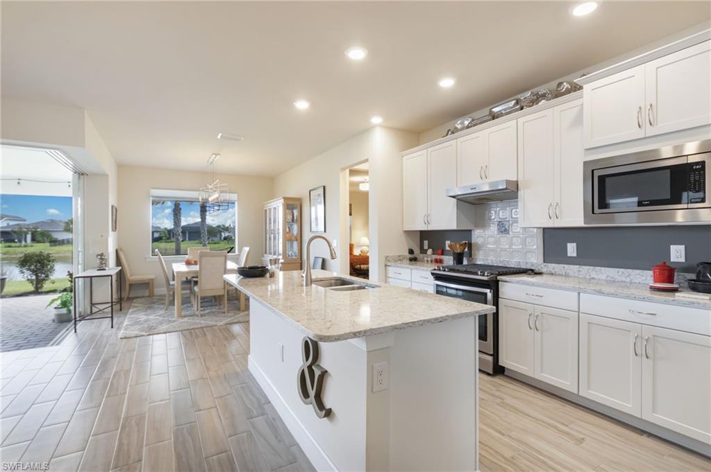 43007 Parkside Court Punta Gorda, FL 33982 - Photo 8 of 44 a large kitchen with stainless steel appliances granite countertop a lot of counter space and wooden floors
