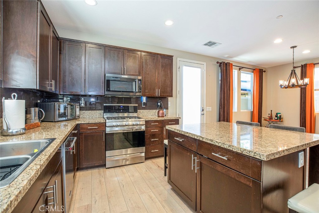 8656 Winnetka Avenue Winnetka, CA 91306 - Photo 11 of 31 a kitchen with kitchen island granite countertop a sink stove and cabinets