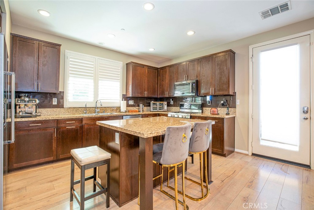 8656 Winnetka Avenue Winnetka, CA 91306 - Photo 7 of 31 a kitchen with stainless steel appliances granite countertop wooden cabinets a sink and a stove
