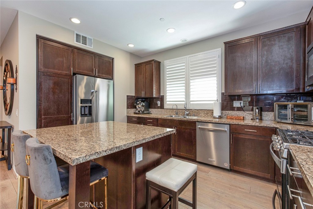8656 Winnetka Avenue Winnetka, CA 91306 - Photo 9 of 31 a kitchen with granite countertop a table chairs microwave and refrigerator