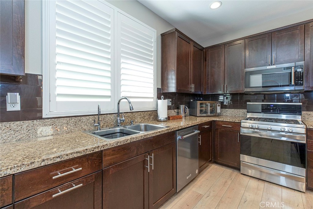 8656 Winnetka Avenue Winnetka, CA 91306 - Photo 10 of 31 a kitchen with granite countertop cabinets stainless steel appliances a sink and window