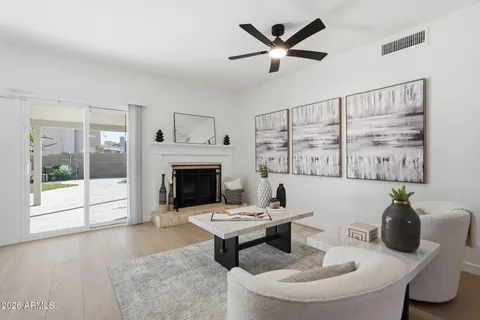 a living room with furniture a fireplace and a large window