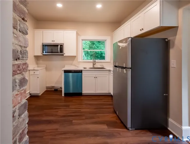a kitchen with stainless steel appliances a refrigerator sink and microwave