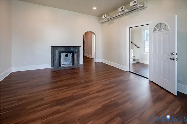 an empty room with wooden floor and mirror