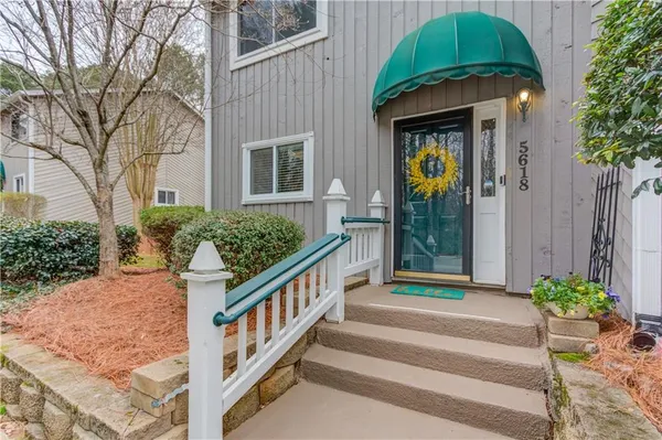 a front view of a house with plants and entryway