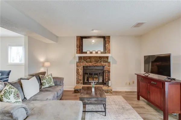 a living room with furniture a flat screen tv and a fireplace