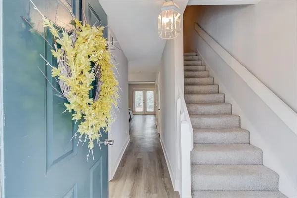a view of a hallway with wooden floor and stairs