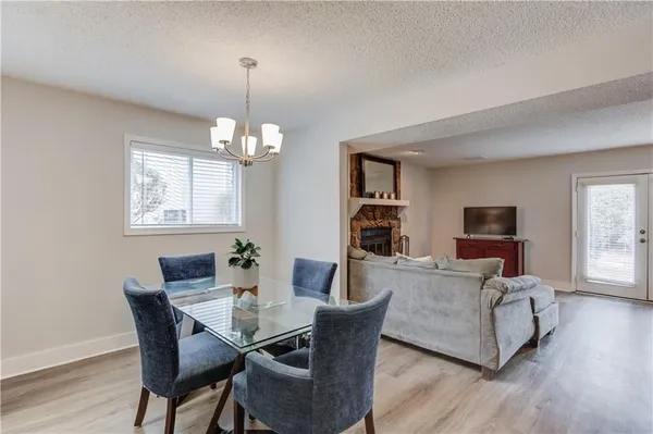 a dining room with furniture a chandelier and wooden floor