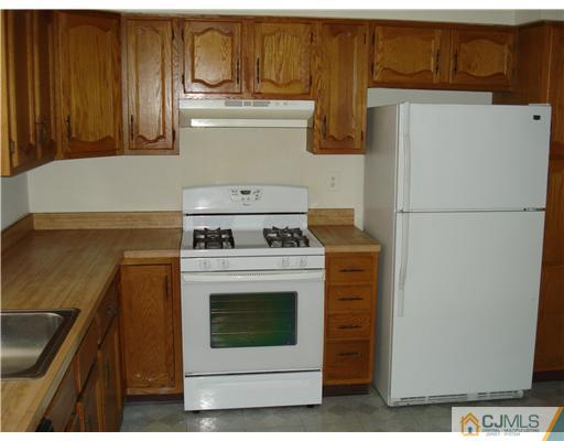 604 Timber Oaks Road Edison, NJ 08820 - Photo 13 of 18 a kitchen with refrigerator a stove and cabinets
