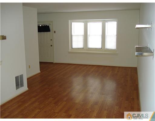604 Timber Oaks Road Edison, NJ 08820 - Photo 8 of 18 a view of an empty room with wooden floor and a window