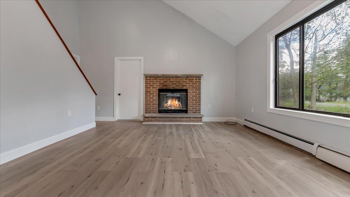 7198 Rimrock Drive Tobyhanna, PA 18466 - Photo 8 of 38 a view of an empty room with wooden floor fireplace and a window
