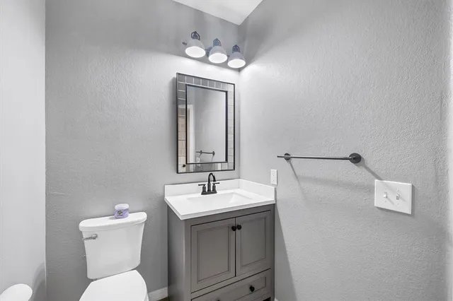 a bathroom with a toilet a sink and mirror