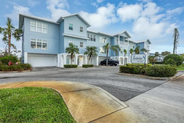 a front view of a house with a yard and potted plants