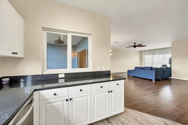a kitchen with granite countertop a sink and white cabinets