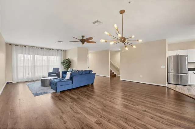 a living room with furniture and a wooden floor