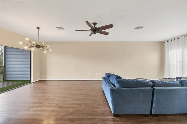 a living room with furniture and a ceiling fan