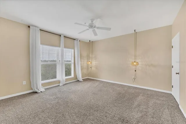 a view of an empty room with a ceiling fan
