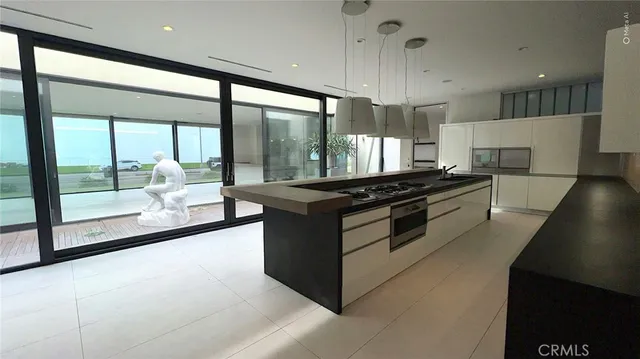 a view of an empty room with wooden floor and windows