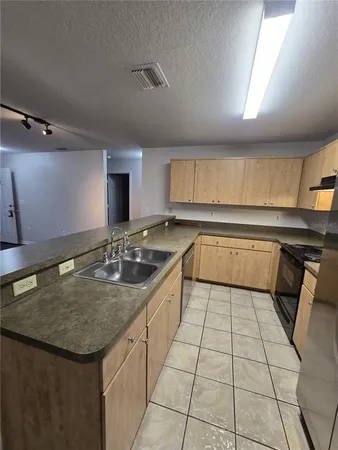 a kitchen with a sink a counter top space cabinets and stainless steel appliances