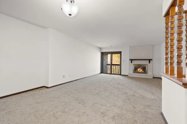 a view of an empty room with a fireplace and a window