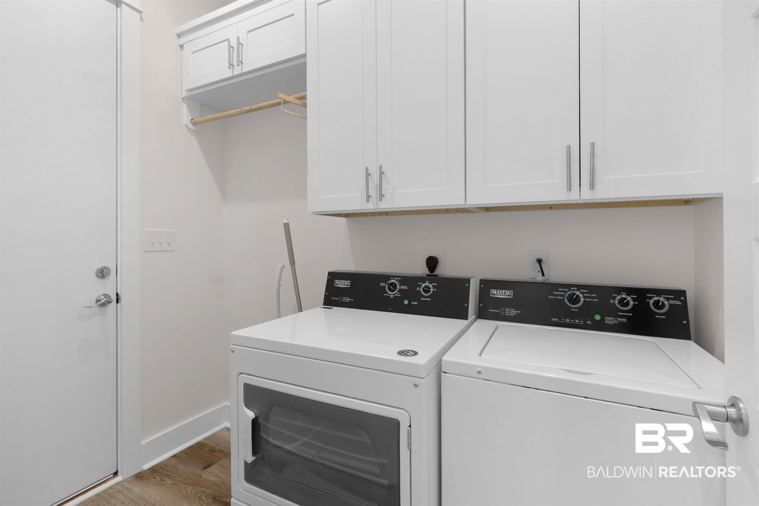 8069 Carmel Circle Foley, AL 36535 - Photo 22 of 23 Laundry room with washing machine and clothes dryer, cabinet space, baseboards, and wood finished floors